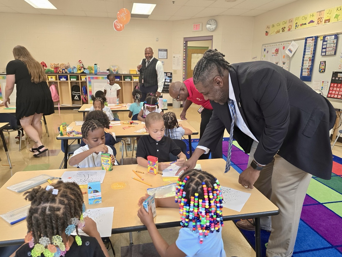 Dr. Grubbs visiting with students during a classroom art activity